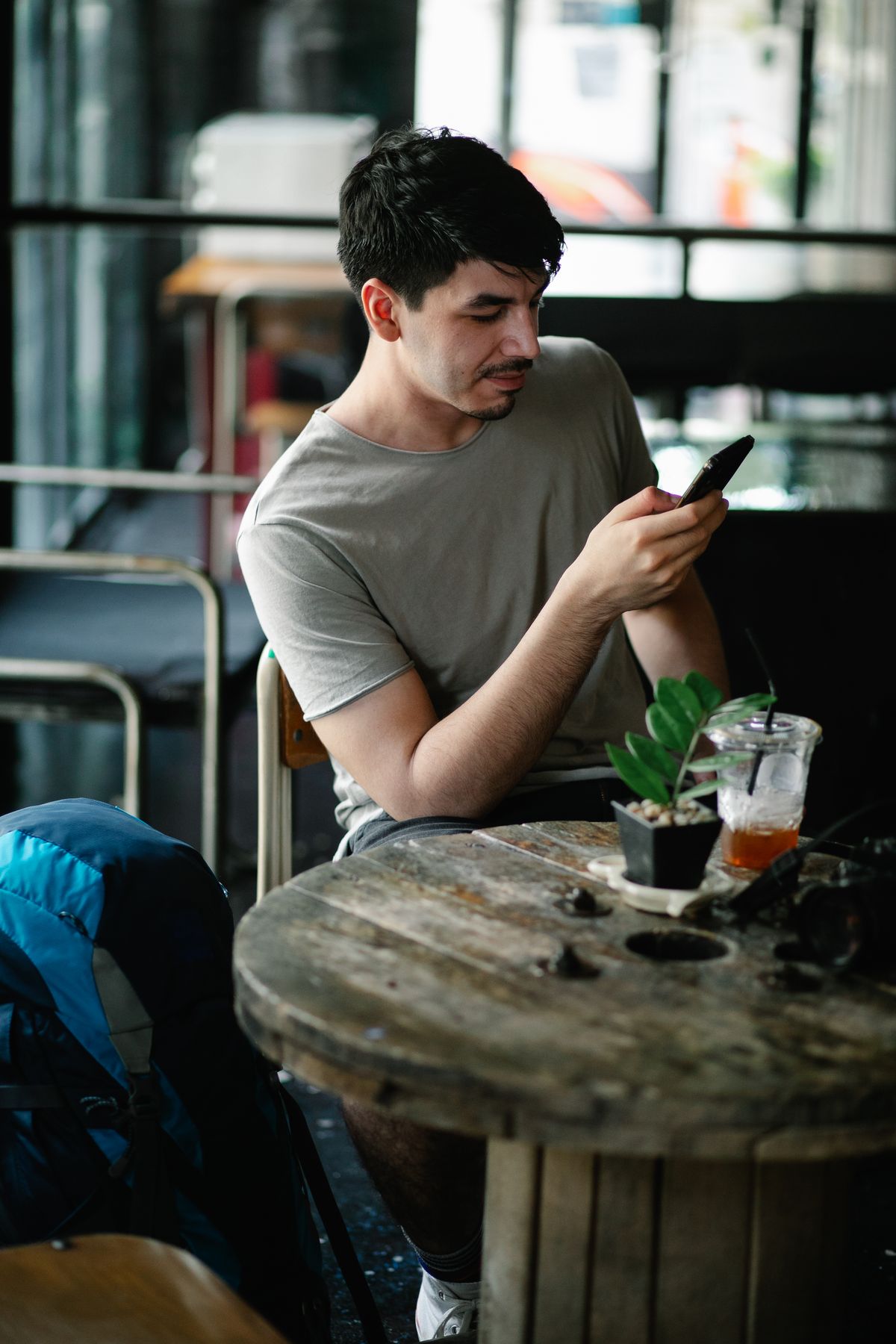 カフェでスマートフォンを操作する人物